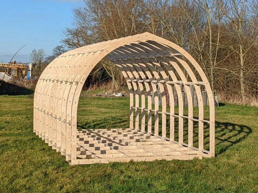 Shropshire CNC glamping pod frame kit, 4.2m wide modular building with metal and wood components, assembled structure in outdoor setting.