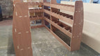 VW Transporter T5 long wheelbase van racking system with plywood shelves for storage and organization of tools and supplies.