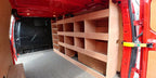Ford Custom van racking with plywood shelving and deep storage case installed in a long wheelbase van interior.