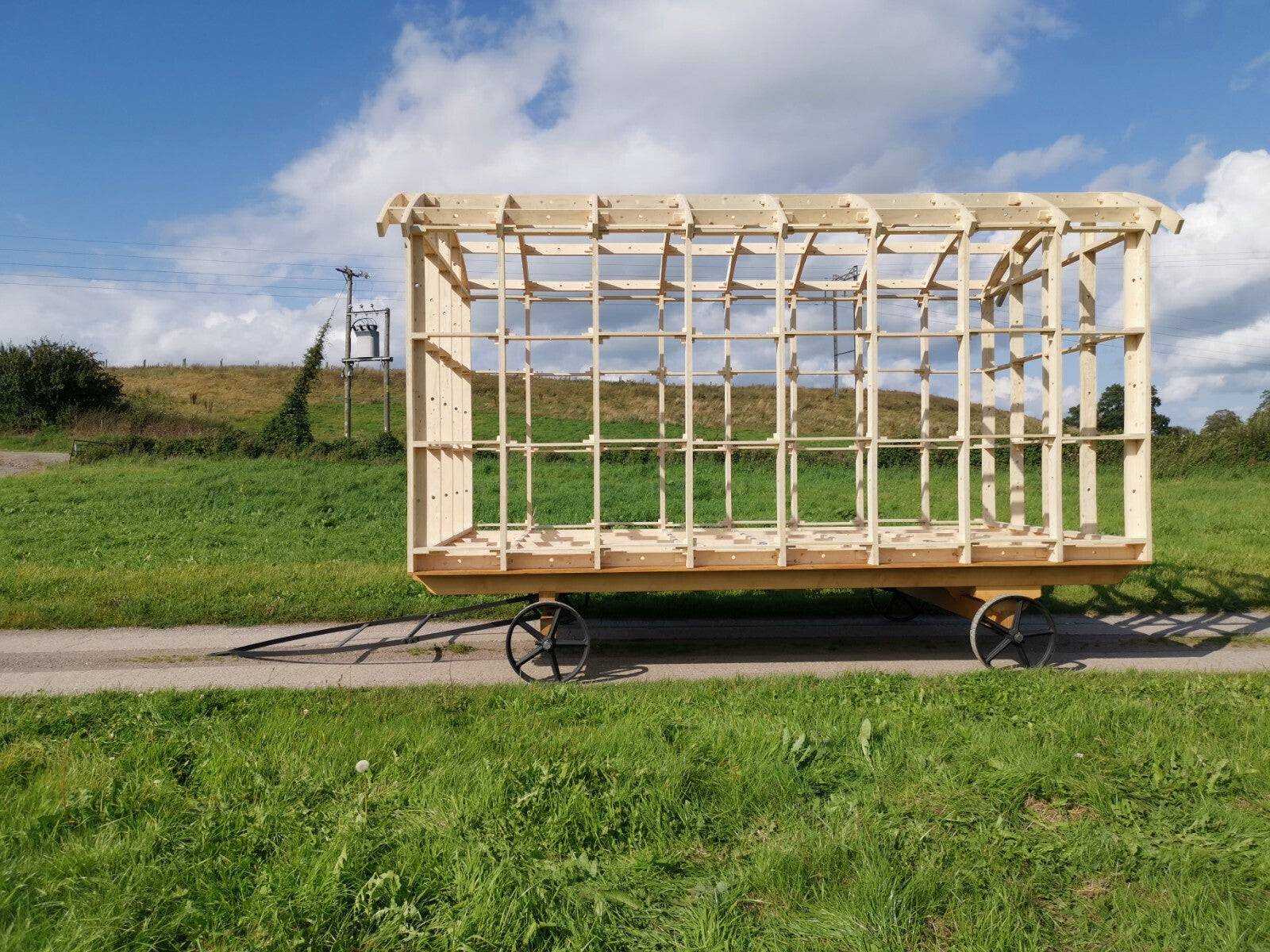 Shropshire CNC shepherd's hut frame kit with modular building components, showing the assembled wooden structure outdoors.