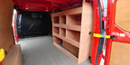 Ford Custom van racking with plywood shelving and deep tool storage in a long wheelbase van interior.