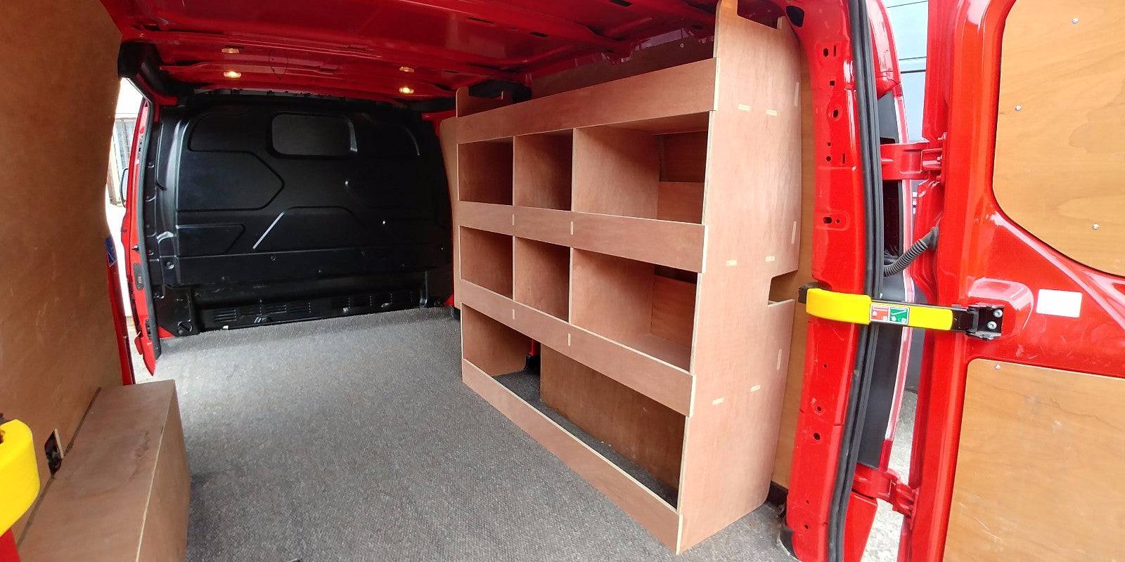 Ford Custom van racking with plywood shelving and deep tool storage in a long wheelbase van interior.