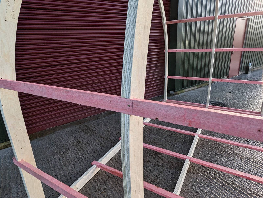 Shropshire CNC glamping pod frame arch kit, 3.2m modular building structure with metal supports and wooden panels.