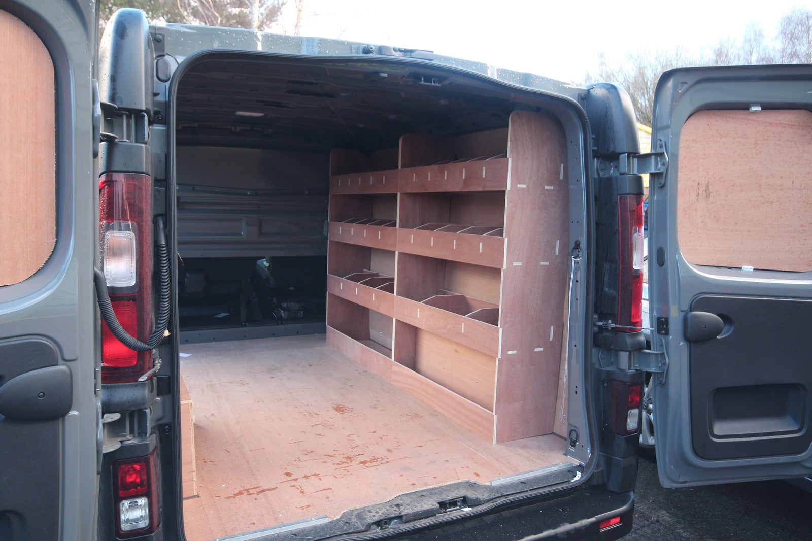 Fiat Talento SWB van with double unit plywood shelving racking for tool organization in the cargo area.