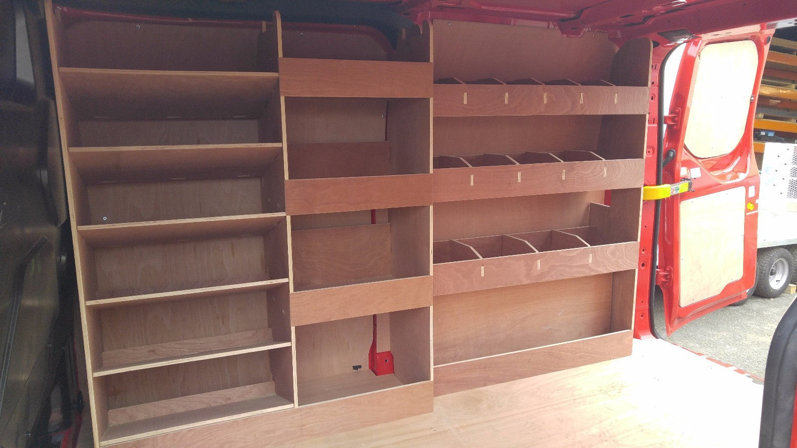 Ford Custom SWB plywood racking storage shelf system in van, including pass side rear, for commercial vehicle organization and storage.