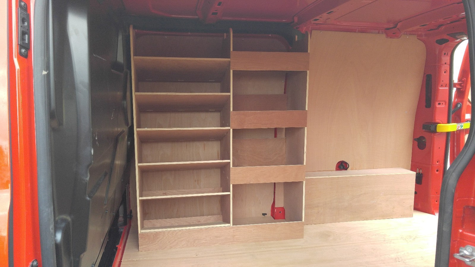 Ford Custom van racking with plywood shelving and deep storage drill/service case for commercial van organization.