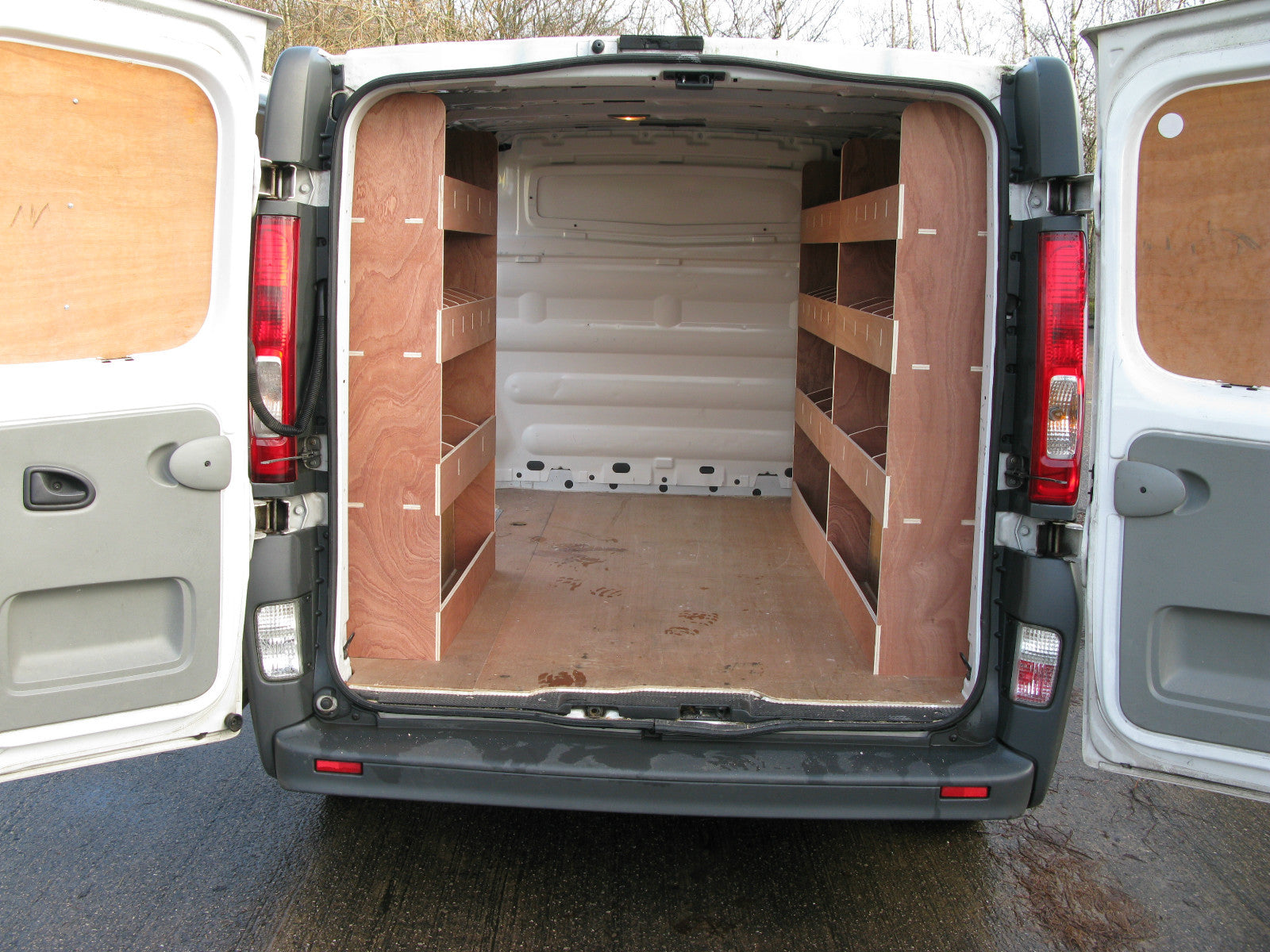 Renault Trafic SWB Van 2008-2013 with plywood shelving and storage racks for tool organization and vehicle customization.