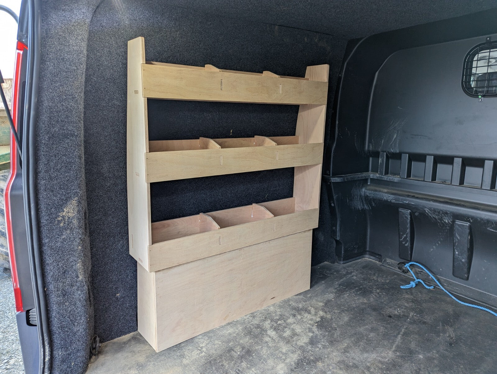 RS Ford Transit Custom plywood van shelving and racking over wheel box for organized tool storage in commercial vehicles.
