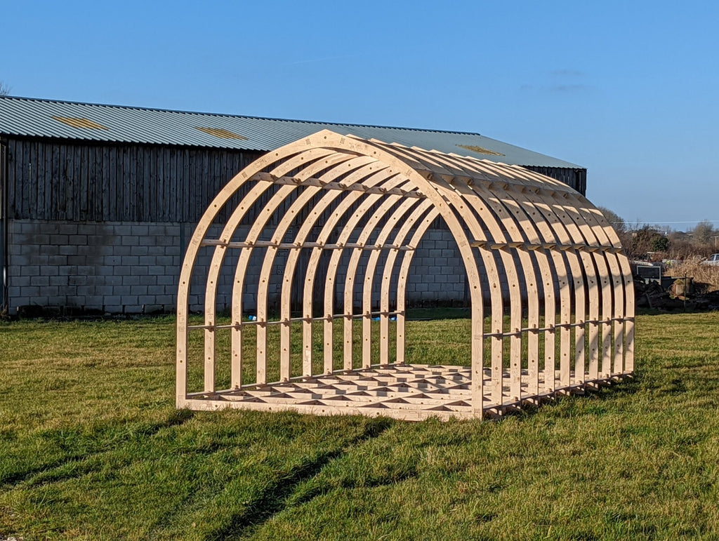Shropshire CNC modular glamping pod frame kit, 4.0m wide, with wooden beams and structural components for outdoor accommodation.